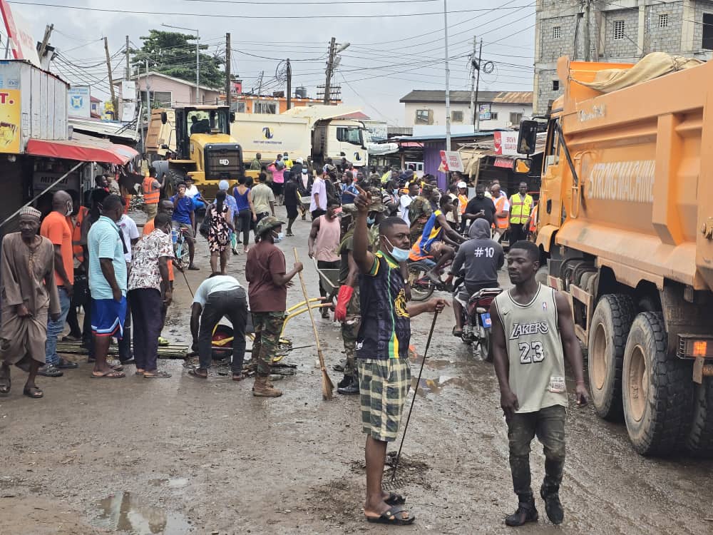 Volunteers clearing a flooded street in Alajo
